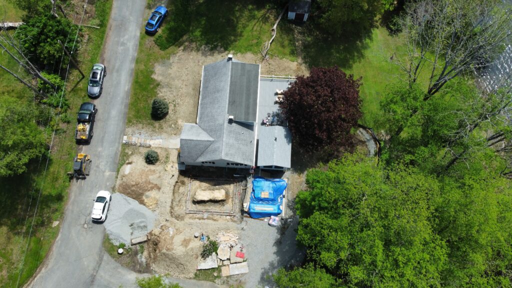 Aerial view of the lakeside property during excavation for the new garage addition.