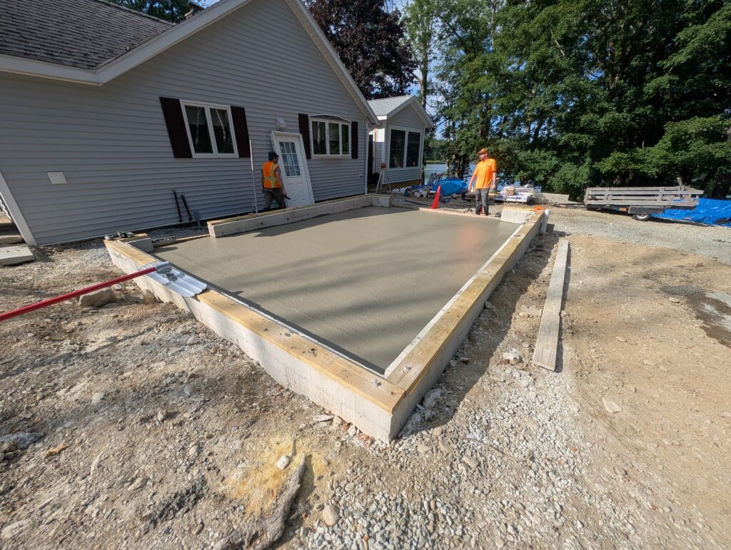 Completed concrete slab and foundation for the garage addition beside the existing home.