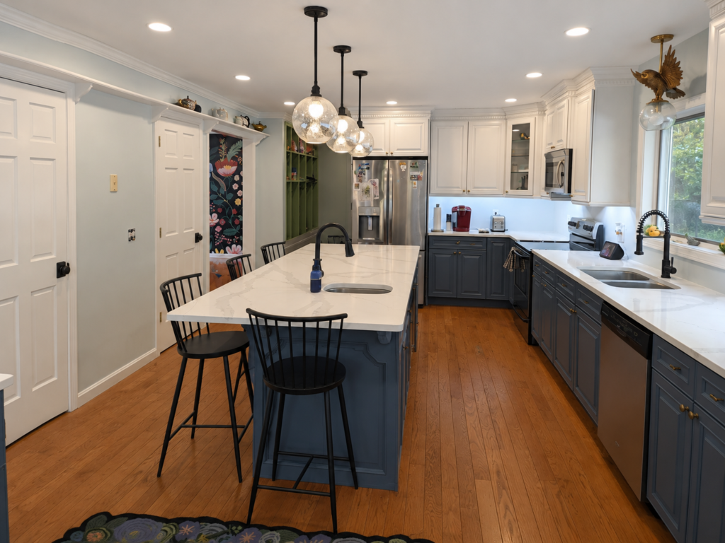 Completed Lakeside Kitchen showing white upper cabinets, blue-gray lower cabinets, quartz counters and black pendant lighting