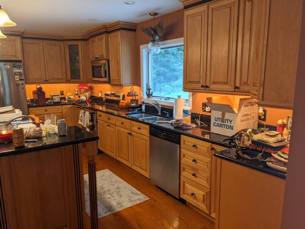 Lakeside Kitchen before remodeling with natural wood cabinets, dark countertops and a raised island