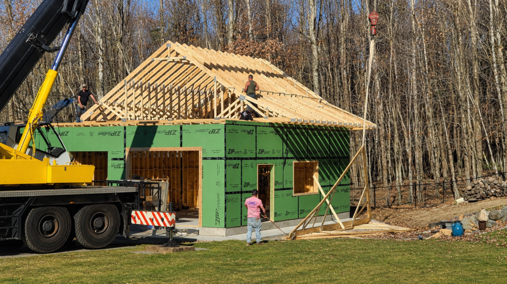 Modern Carriage House under construction with framed walls, ZIP sheathing and roof trusses being installed