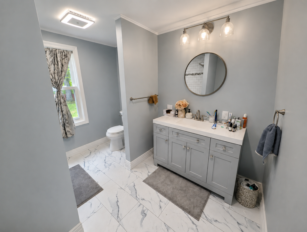 Completed bedroom-to-bathroom conversion with a gray vanity, marble-look floor tile and new lighting