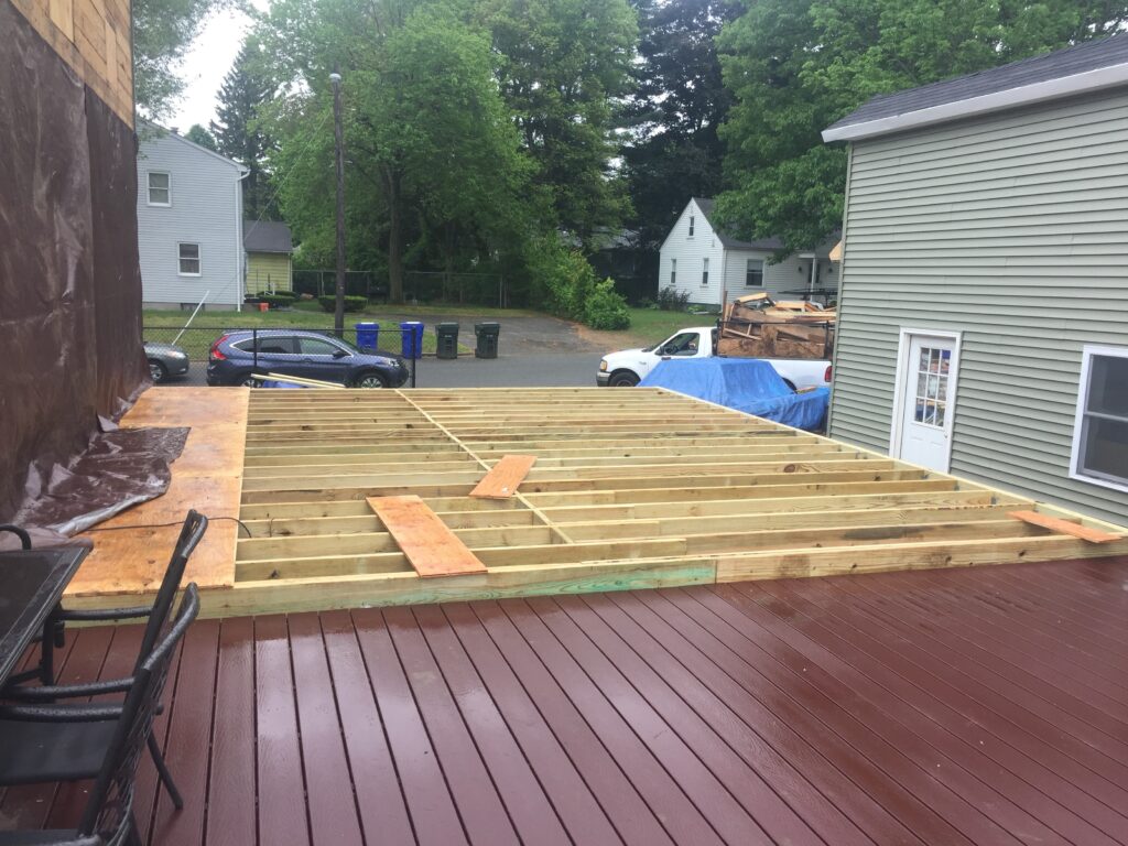 Floor joists for the 20-by-20 home addition framed beside the existing rear deck