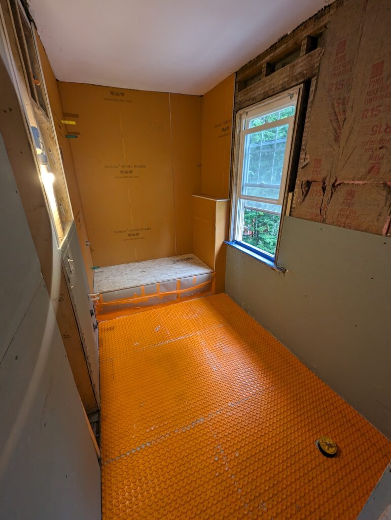 Bathroom waterproofing and heated-floor preparation using Schluter KERDI-BOARD and an uncoupling membrane