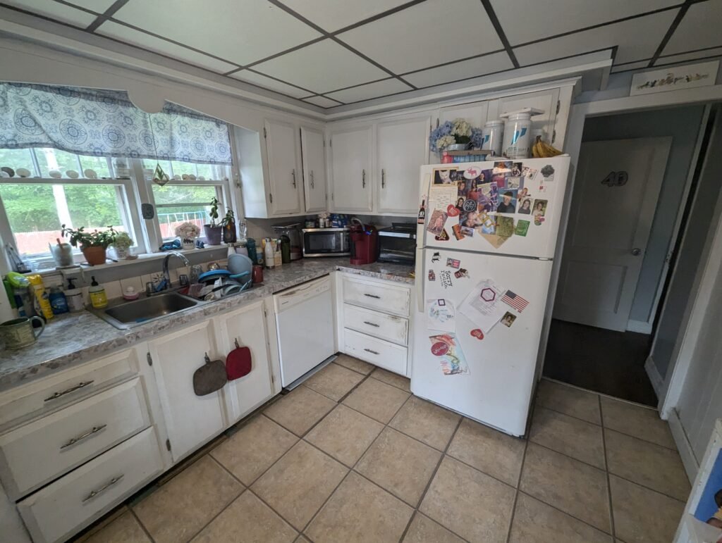 Galley kitchen during renovation with the suspended ceiling removed and older wiring exposed