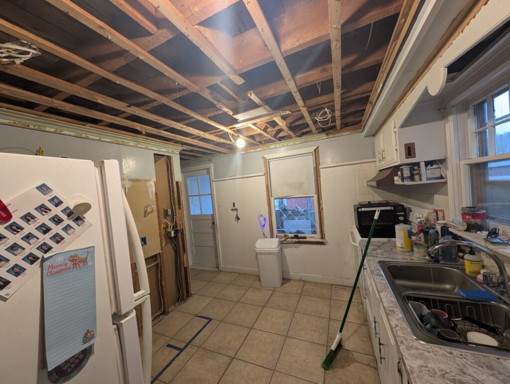 Original narrow kitchen with a suspended ceiling, tile floor and inefficient appliance arrangement