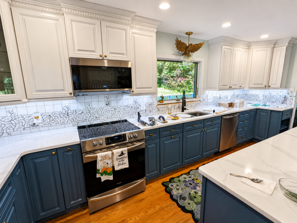 Completed Lakeside Kitchen with a custom woodland tile backsplash, white upper cabinets and blue-gray lower cabinets