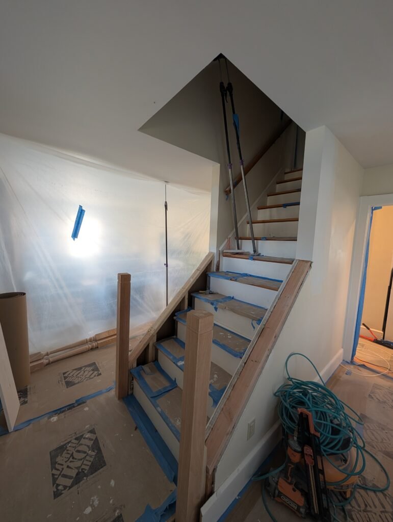 Kitchen during demolition with exposed framing, wiring and flooring before reconstruction